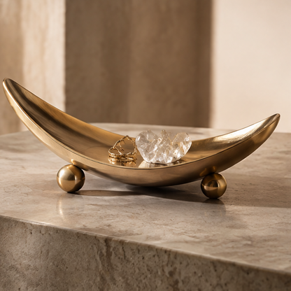 Gold crescent boat-form metal tray with crystal and rings — clean background