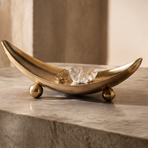 Gold crescent boat-form metal tray with crystal and rings — clean background