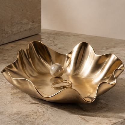 Gold wave-edge smooth metal tray with marble ball and bracelet — clean background