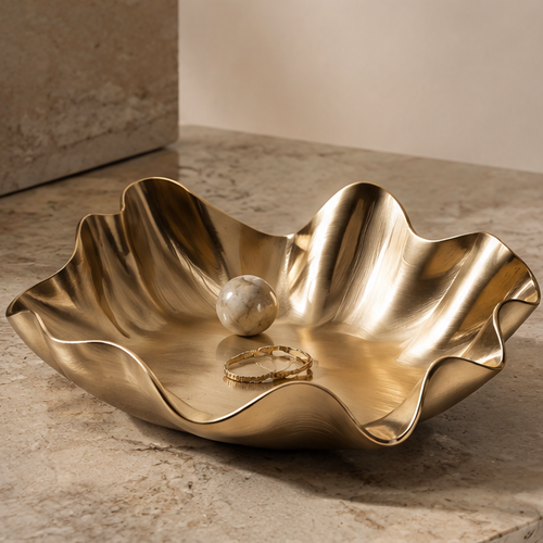 Gold wave-edge smooth metal tray with marble ball and bracelet — clean background