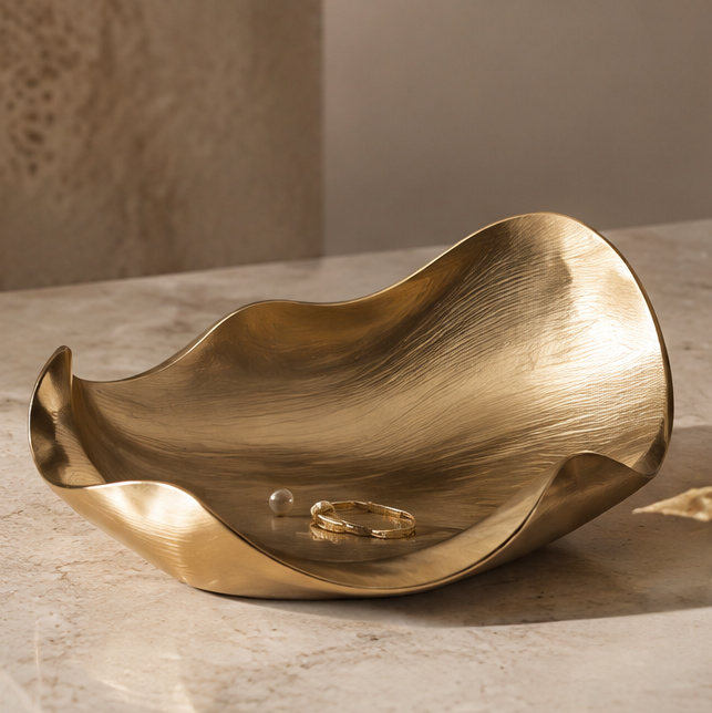 Gold twisted leaf brushed metal tray with ring and pearl — clean background
